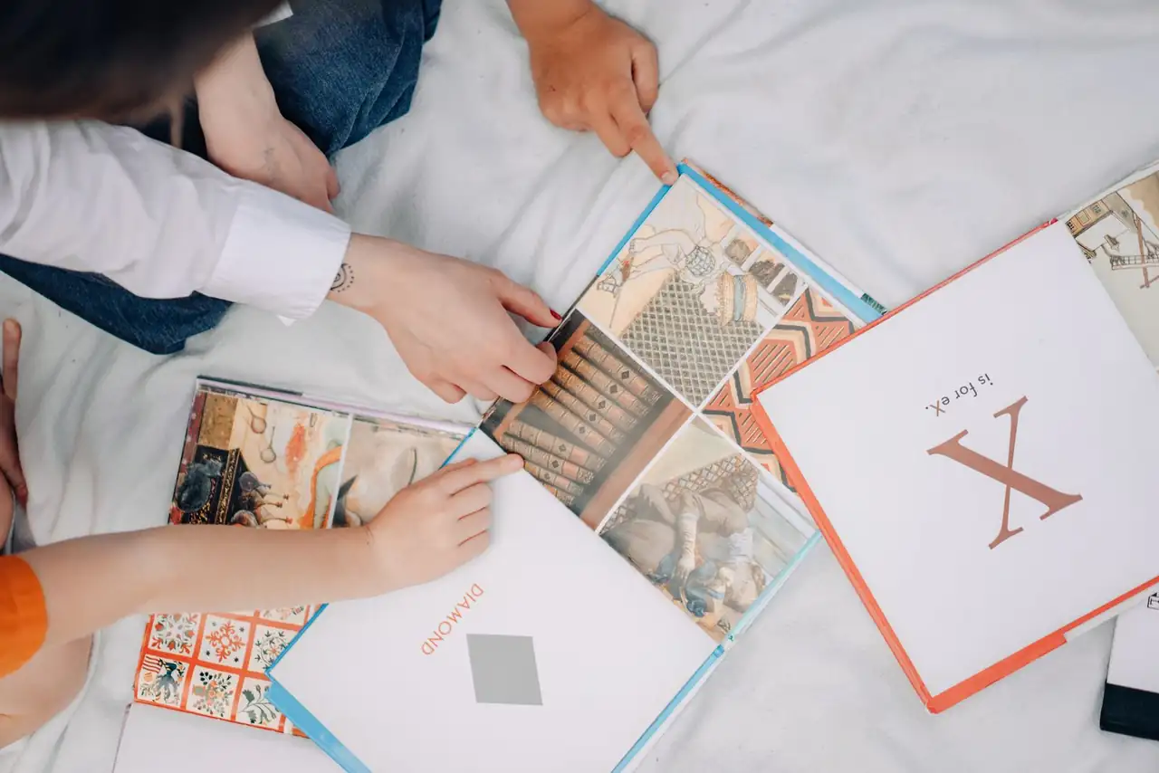 Top view of children exploring colorful illustrated books, fostering learning and interaction.